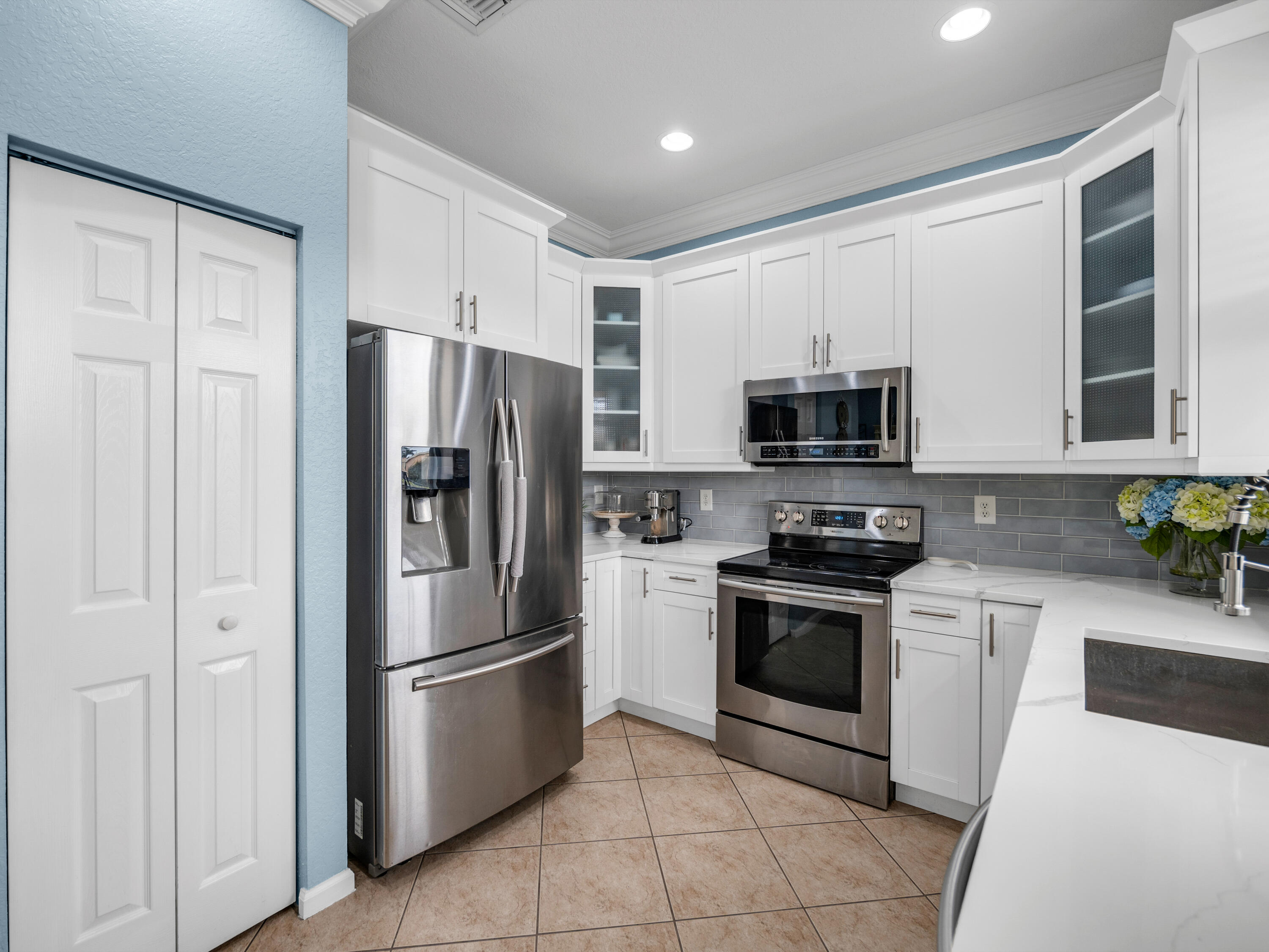 7951 Red Mahogany Road Boynton Beach, FL 33437 - Photo 14 of 33 a kitchen with stainless steel appliances granite countertop a refrigerator stove and microwave