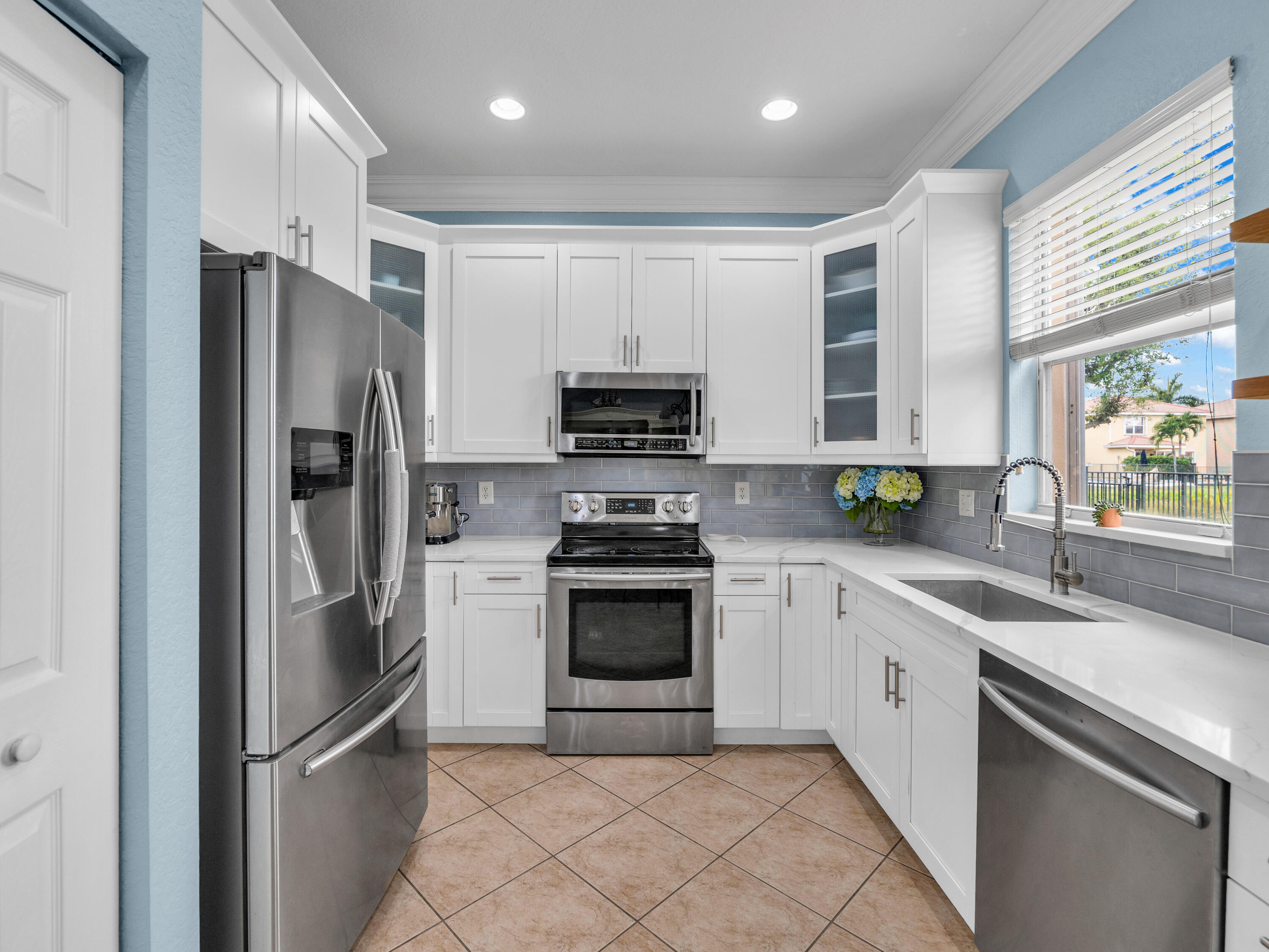 7951 Red Mahogany Road Boynton Beach, FL 33437 - Photo 15 of 33 a kitchen with stainless steel appliances granite countertop a refrigerator a sink a stove top oven and a refrigerator