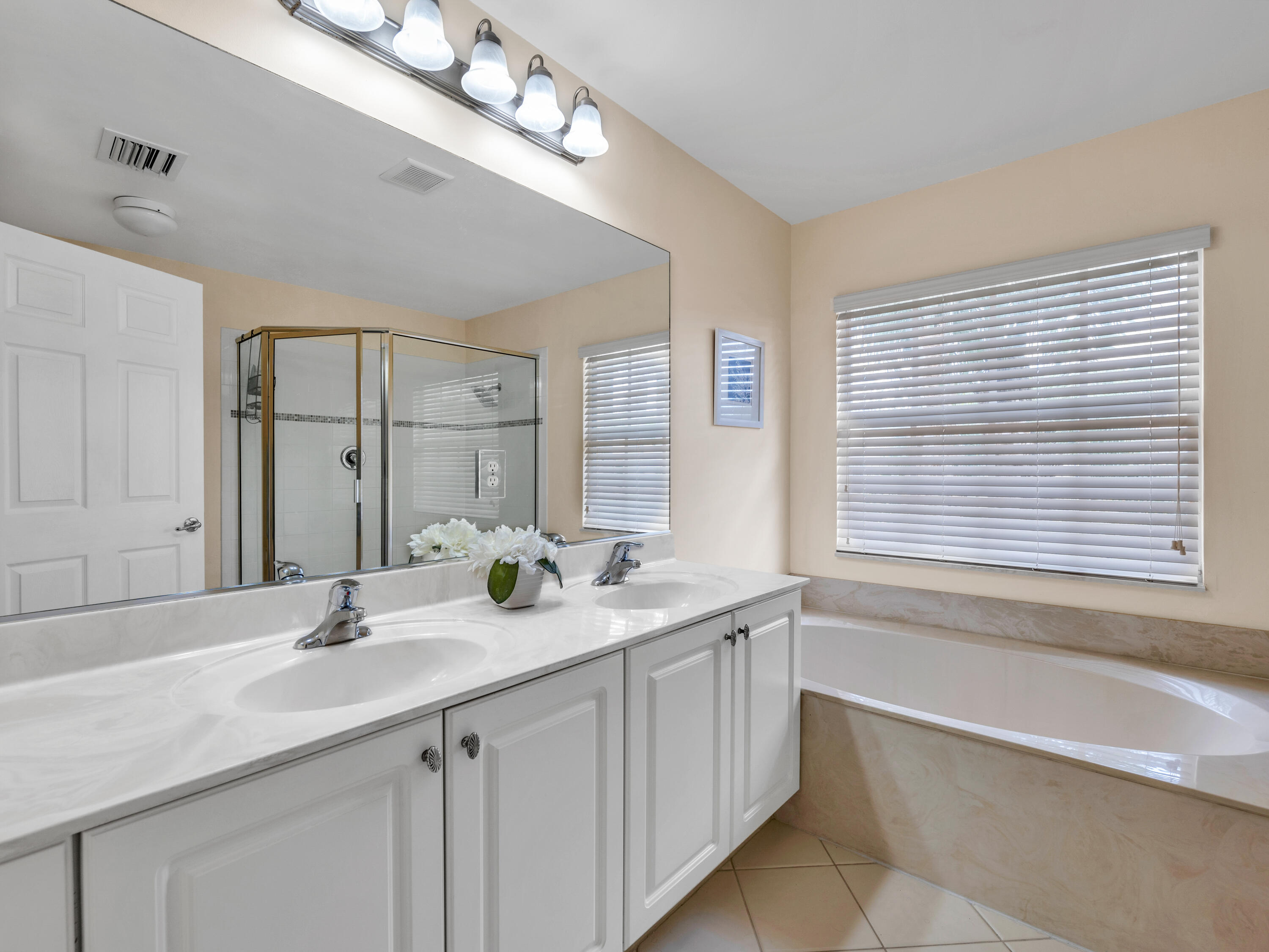 7951 Red Mahogany Road Boynton Beach, FL 33437 - Photo 19 of 33 a bathroom with a tub a sink and mirror