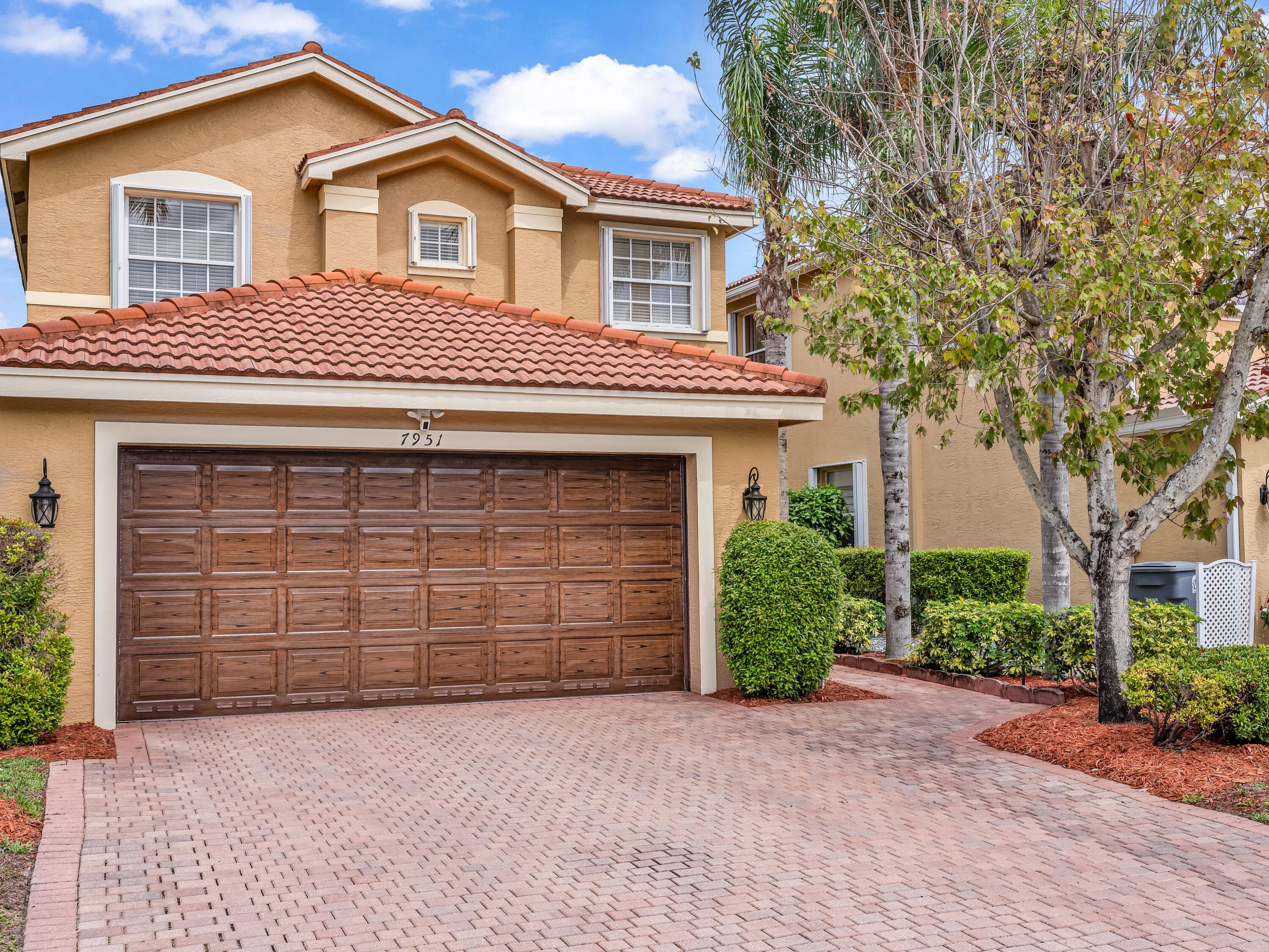 7951 Red Mahogany Road Boynton Beach, FL 33437 - Photo 2 of 33 a front view of a house with a yard and garage