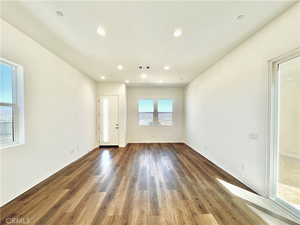 27391 Powder Ridge Court Valencia, CA 91381 - Photo 6 of 22 an empty room with wooden floor and windows