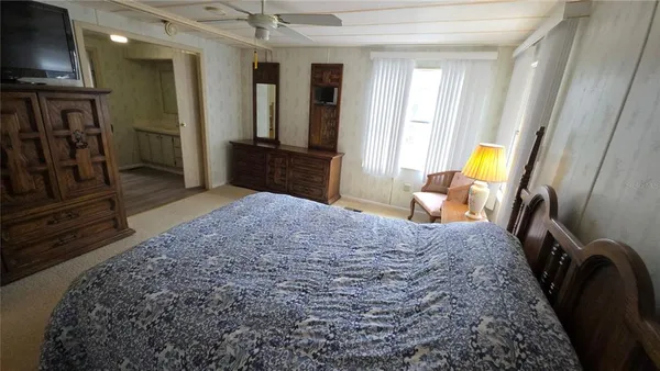 a bedroom with a bed closet and a flat tv screen