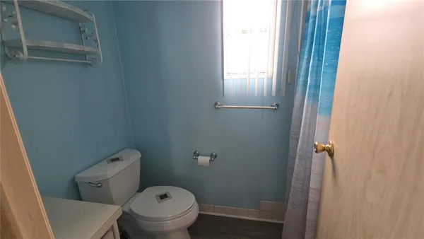 a white toilet sitting next to a window