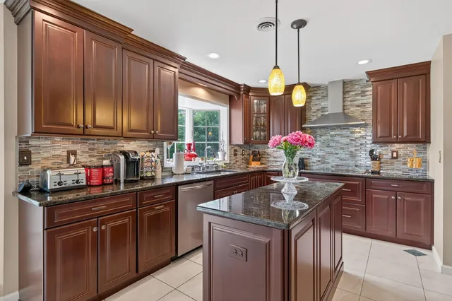a kitchen with kitchen island granite countertop a sink stainless steel appliances and cabinets