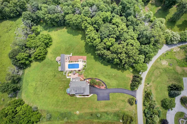 an aerial view of a house with swimming pool and garden