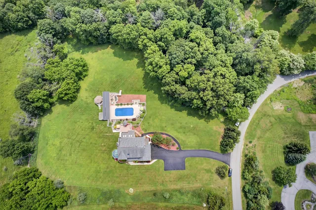 an aerial view of a house with swimming pool and garden