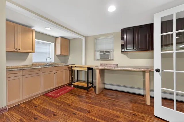 a kitchen with a sink cabinets and wooden floor