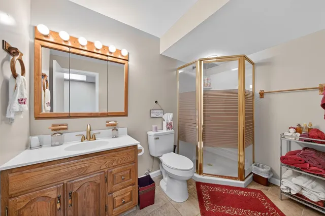 a bathroom with a toilet sink vanity and mirror