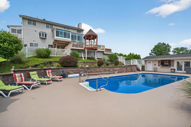 a swimming pool with outdoor seating and yard