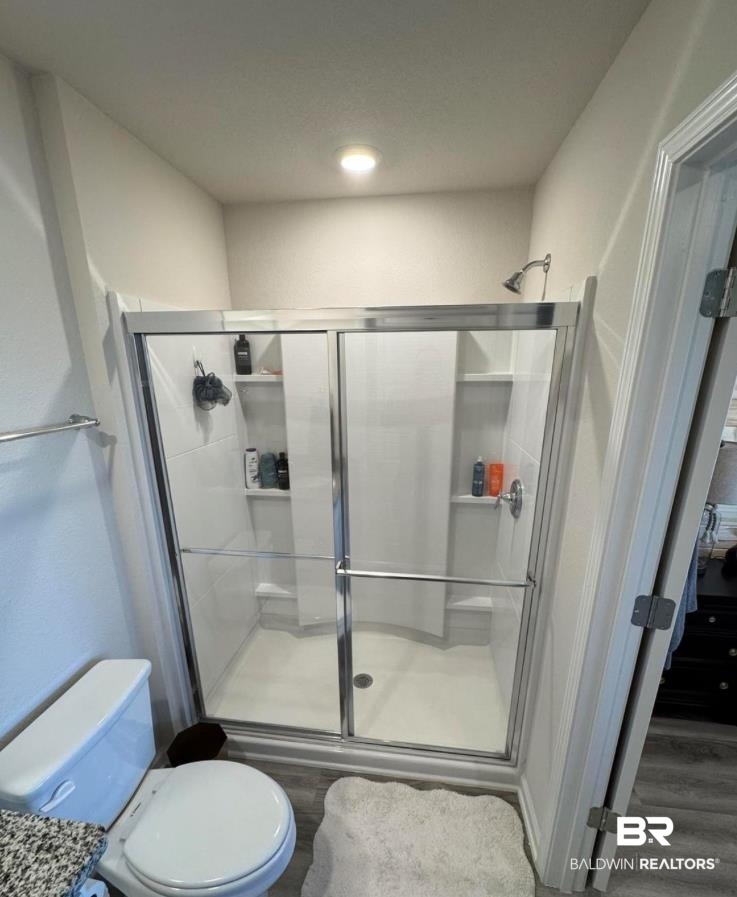 23933 Signor Place Daphne, AL 36526 - Photo 21 of 24 Full bath with a shower stall, toilet, and wood finished floors