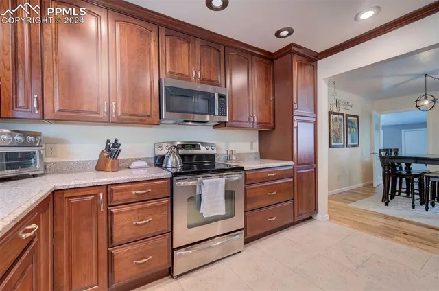 a kitchen with stainless steel appliances granite countertop a stove a sink and a refrigerator