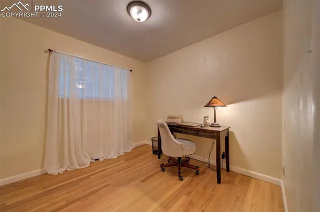 a view of a workspace with furniture and wooden floor