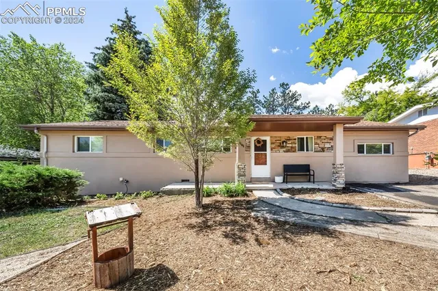 a view of a house with a yard and sitting area
