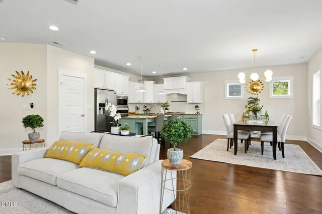 a living room with furniture kitchen view and a window