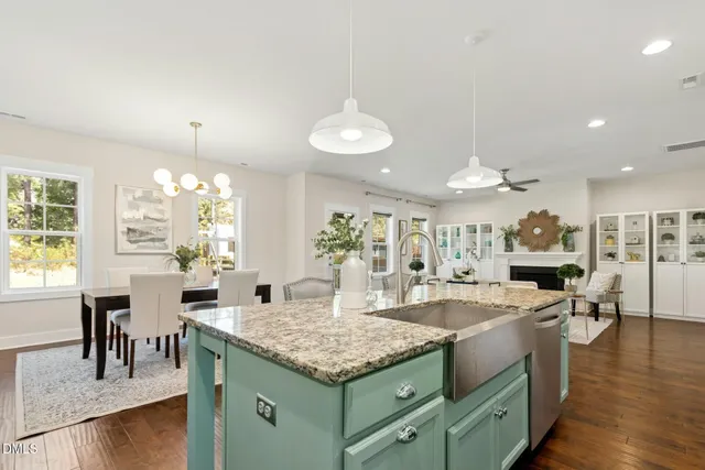 a kitchen with kitchen island granite countertop stainless steel appliances and wooden cabinets