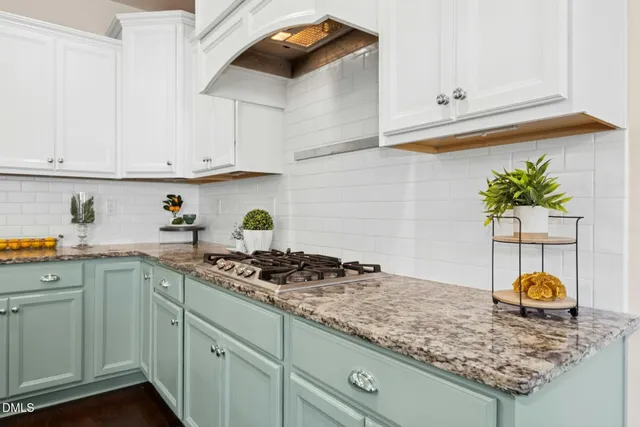 a kitchen with stainless steel appliances granite countertop a sink a stove and cabinets