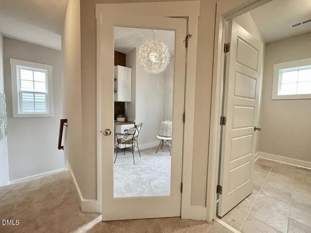 a view of a hallway with wooden floor and a living room