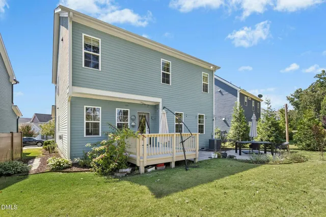 a backyard of a house with table and chairs
