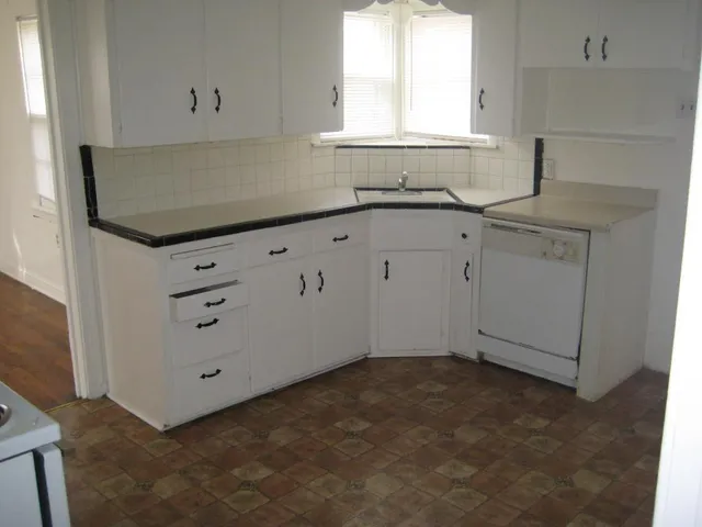 a kitchen with white cabinets and a sink