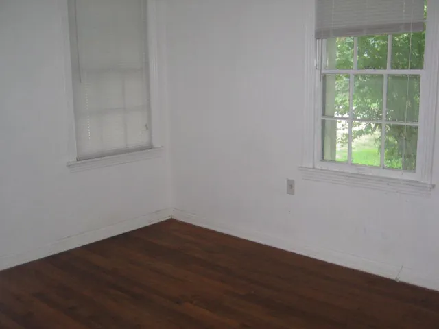 a view of a small space with wooden floor and a window