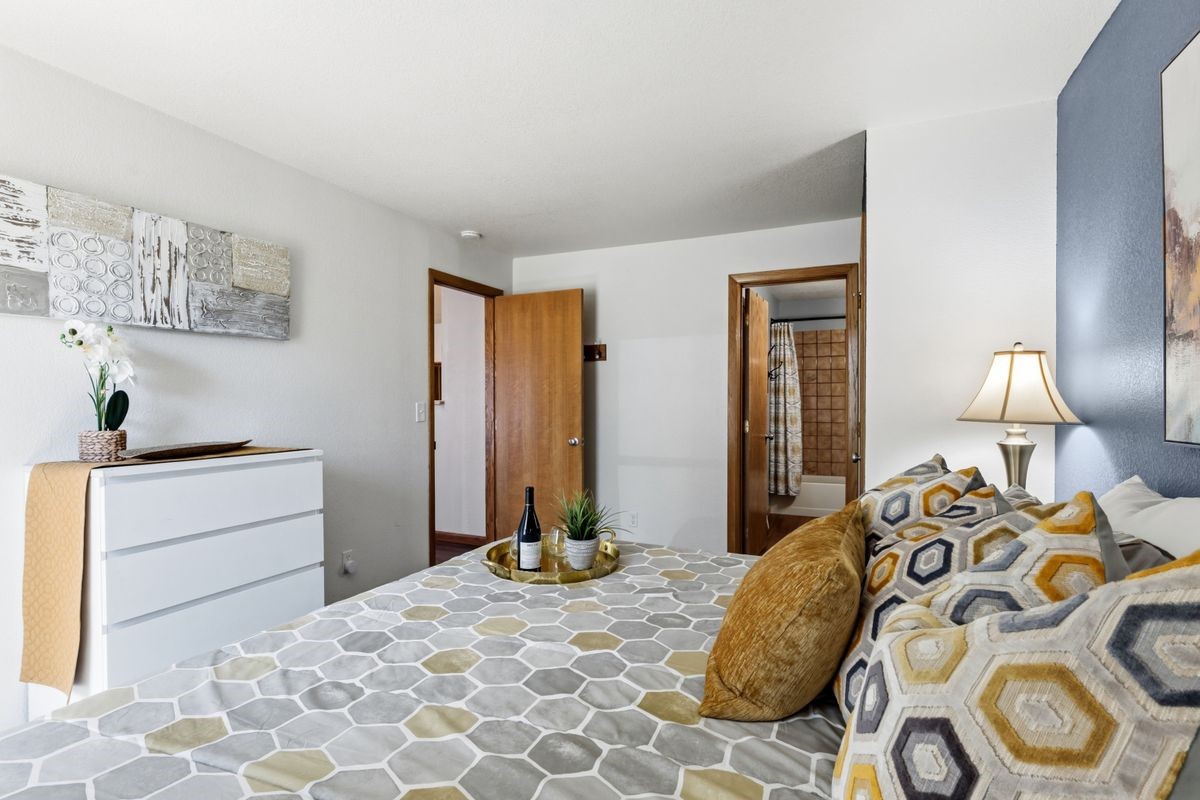 89410 Ryan Gulch Road, Unit 208 Silverthorne, CO 80498 - Photo 16 of 30 a bedroom with a bed and a lamp on dresser