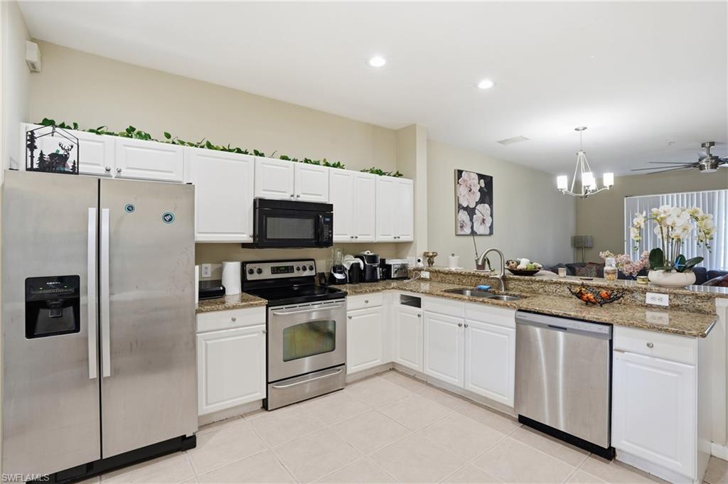 1013 Hampton Circle, Unit 127 Naples, FL 34105 - Photo 2 of 21 a kitchen with granite countertop a sink stainless steel appliances and white cabinets