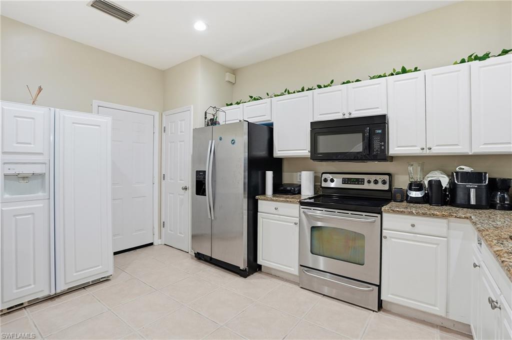 1013 Hampton Circle, Unit 127 Naples, FL 34105 - Photo 3 of 21 a kitchen with stainless steel appliances white cabinets a stove a sink and a refrigerator