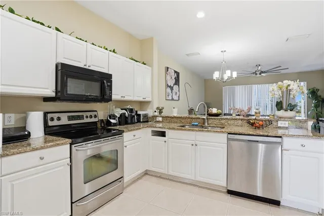 a kitchen with sink a microwave and cabinets