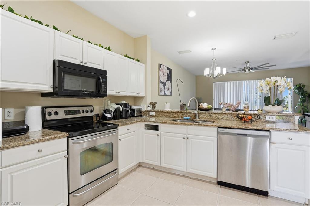 1013 Hampton Circle, Unit 127 Naples, FL 34105 - Photo 4 of 21 a kitchen with sink a microwave and cabinets