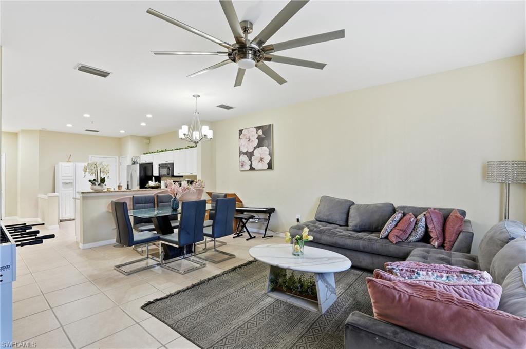 1013 Hampton Circle, Unit 127 Naples, FL 34105 - Photo 5 of 21 a living room with furniture a rug and a chandelier