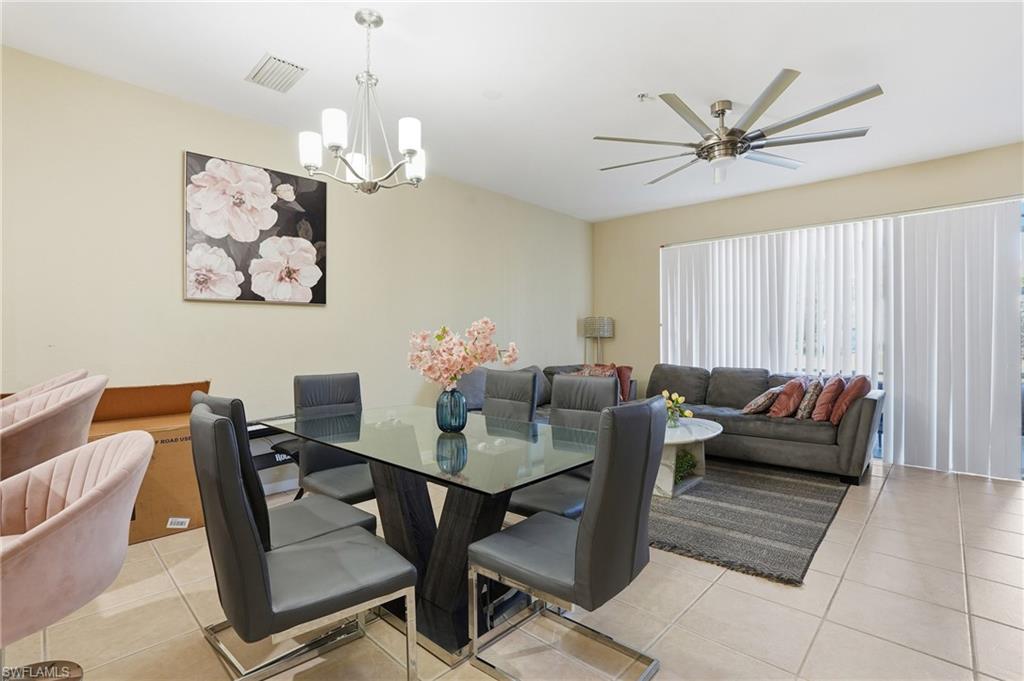 1013 Hampton Circle, Unit 127 Naples, FL 34105 - Photo 7 of 21 a living room with furniture a window and a chandelier