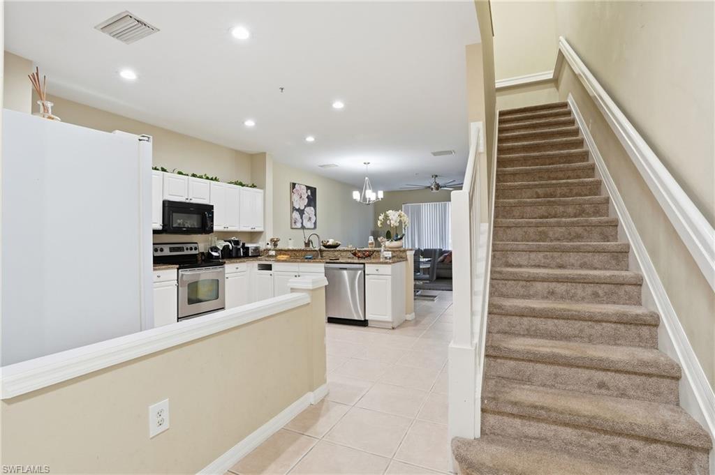 1013 Hampton Circle, Unit 127 Naples, FL 34105 - Photo 10 of 21 a kitchen with white cabinets and stainless steel appliances