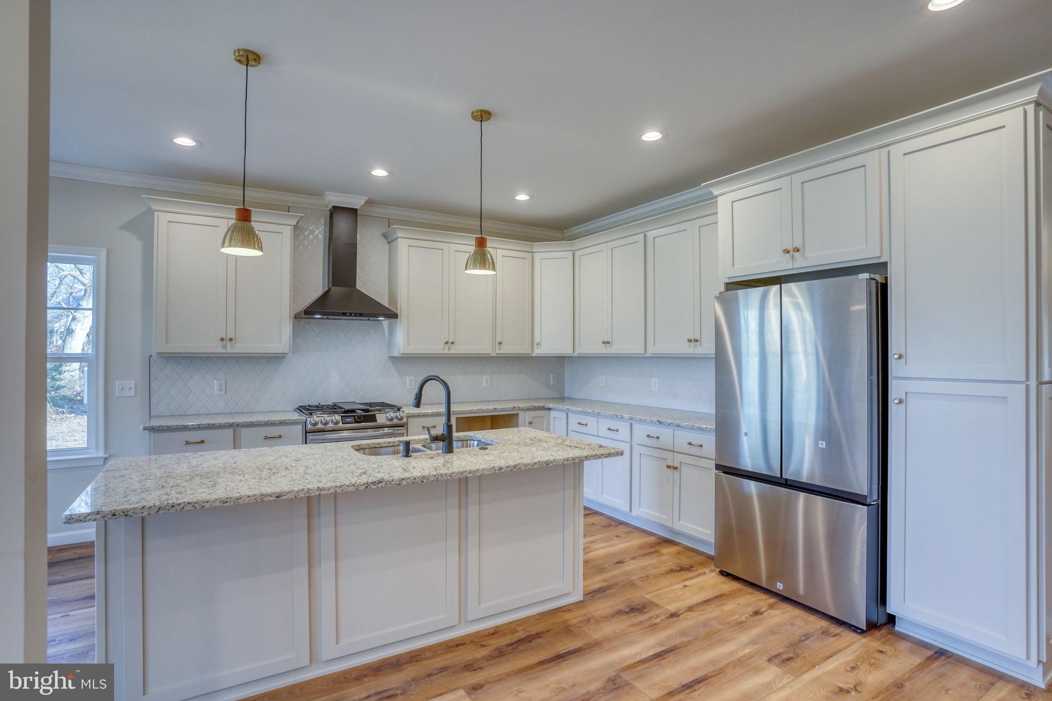39 Doc Court Felton, DE 19943 - Photo 25 of 70 a kitchen with stainless steel appliances granite countertop a refrigerator a sink dishwasher a stove and white countertops with wooden floor