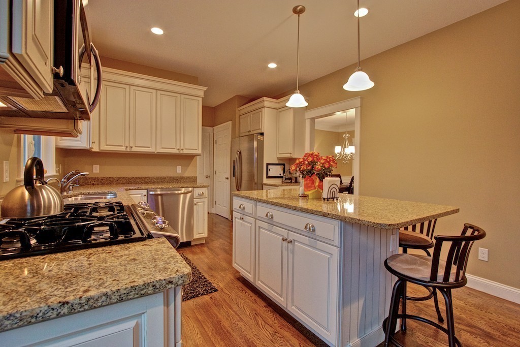 550 Edgell Road Framingham, MA 01701 - Photo 7 of 29 a kitchen with stainless steel appliances granite countertop a sink a stove and a wooden floors