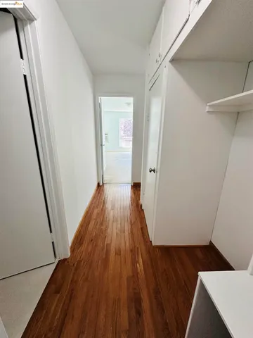 a view of a hallway with wooden floor and staircase
