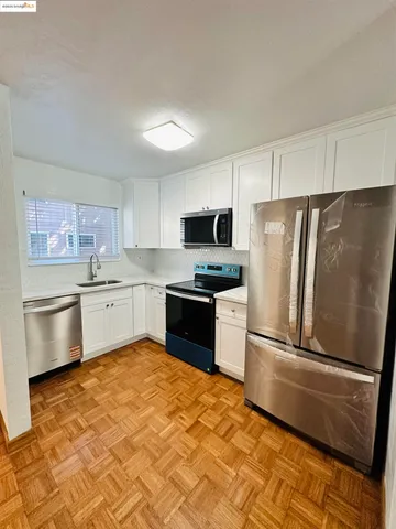 a kitchen with granite countertop a refrigerator stove and sink