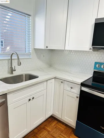 a kitchen with a sink cabinets and a stove top oven
