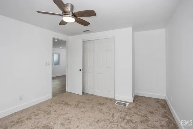 an empty room with fan and entrance