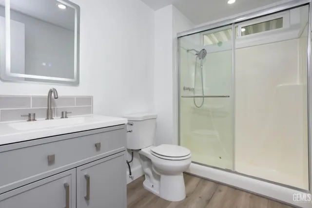 a bathroom with a sink a toilet and shower