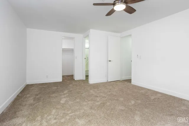 an empty room with a chandelier fan