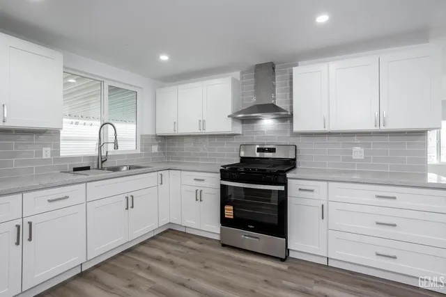 a kitchen with granite countertop white cabinets and appliances