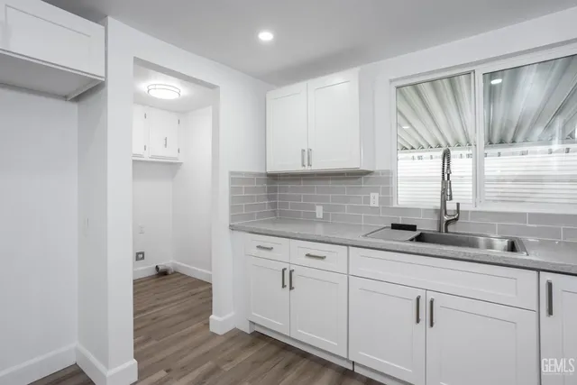 a kitchen with a sink window and cabinets