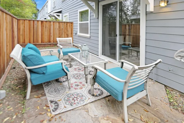 a view of a chairs and table in the back yard of the house