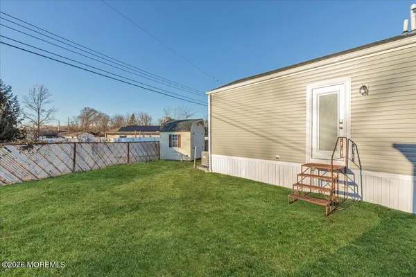 a view of a backyard with plants and wooden fence