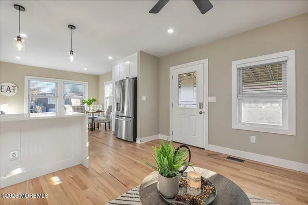 a room with stainless steel appliances kitchen island granite countertop furniture and a wooden floor