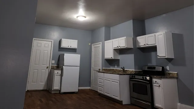 a kitchen with a sink a refrigerator and cabinets