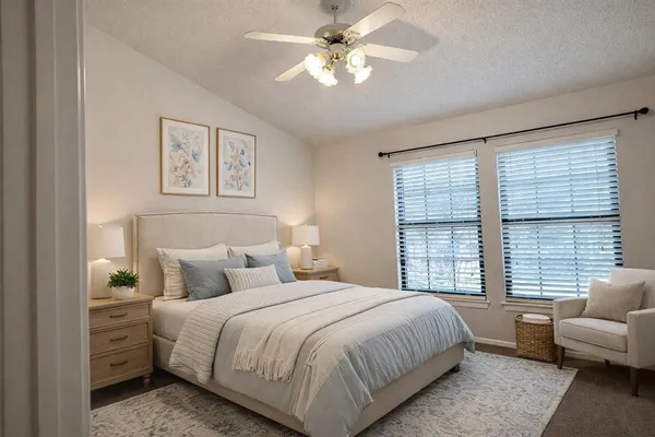 a bedroom with a bed couches and a large window