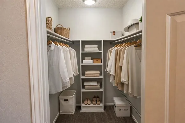 a view of walk in closet with clothes and shoes