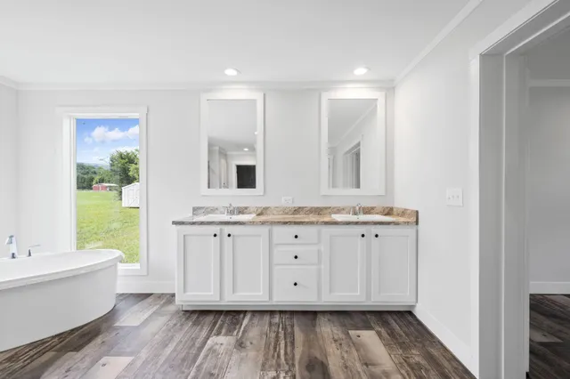 a bathroom with a granite countertop sink mirror and bathtub