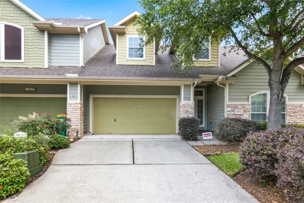 a front view of a house with a yard and a garage